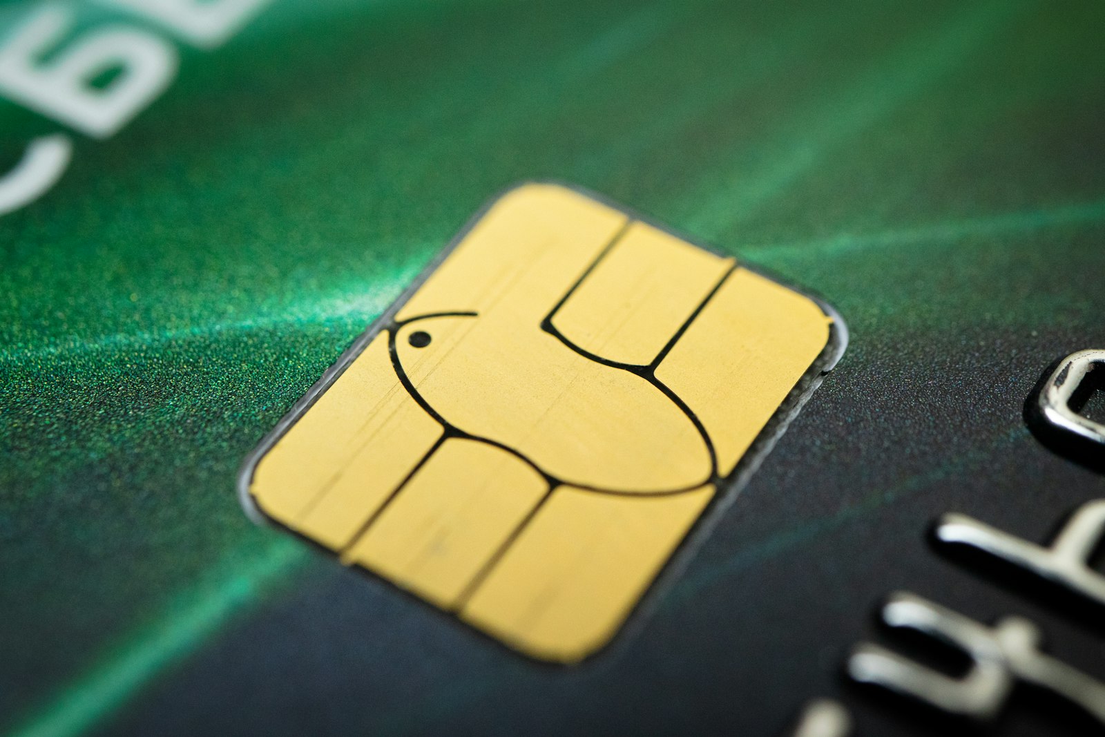 Makroaufnahme des goldenen Chips auf einer grünen Bankkarte