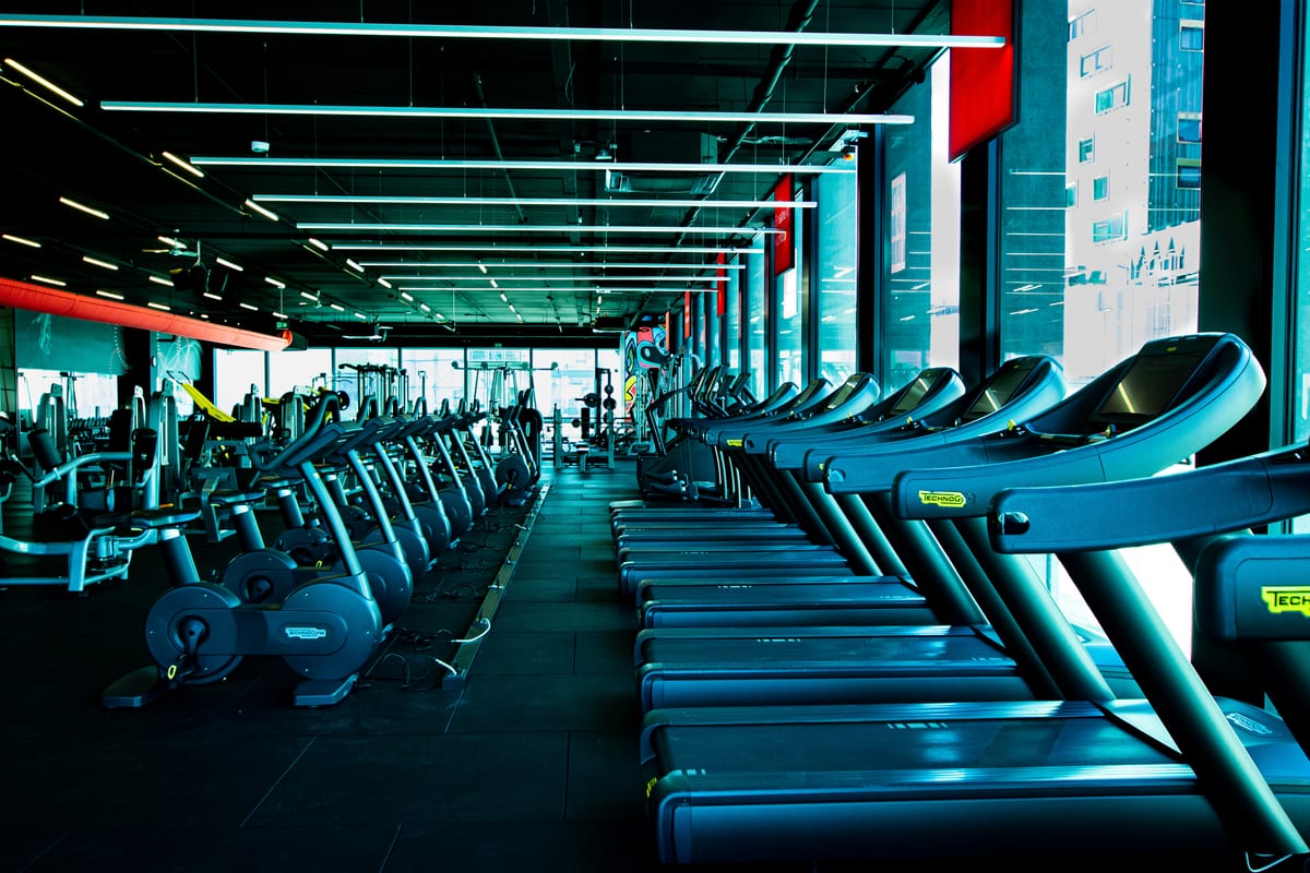 Reihe von Kraftgeräten in der leeren Trainingsfläche eines Fitnessstudios