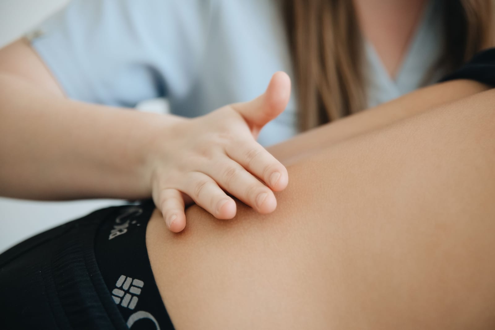 Therapeut behandelt den Rücken eines Patienten mit den Händen – die manuelle Behandlung ist bei den Kassen nur Satzungsleistung