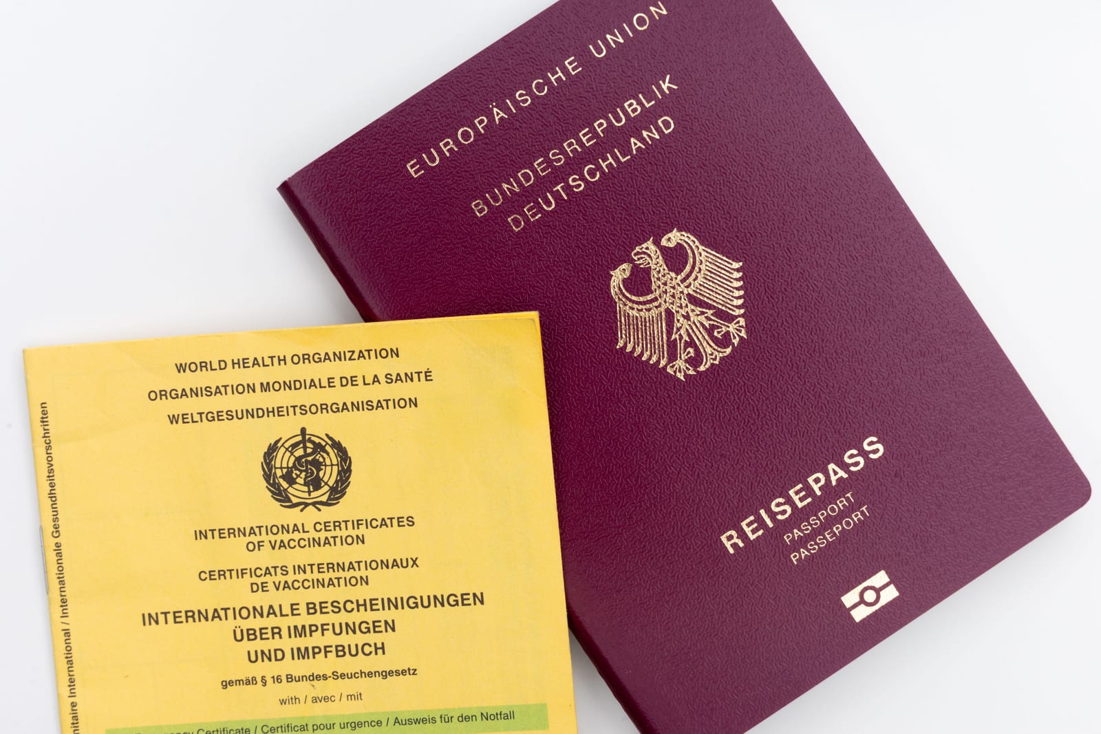 Internationaler Impfausweis neben einem deutschen Reisepass – die Unterlagen, die Sie für das Gespräch über Reiseimpfungen bereithalten sollten